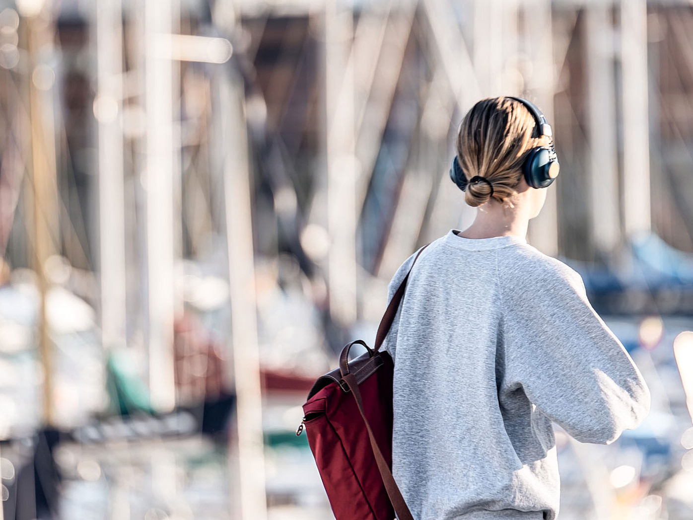 A woman at the harbor wearing headphone